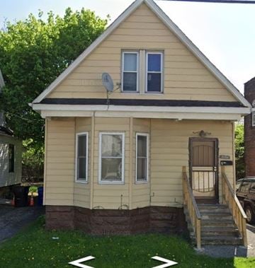 Cleveland house for rent - A small house with a brown door and a satellite dish on the roof.