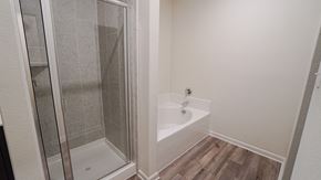 Forney house for rent - A white bathroom with a glass shower door and a white bathtub.