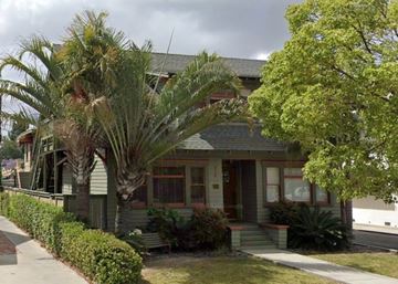 Anaheim apartment for rent - A house with a red door and a palm tree in front.