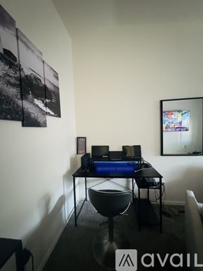 Tucson townhouse for rent - A black and white photo is hanging on the wall above a desk with a computer and a chair is in front of it.