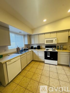Tucson townhouse for rent - A kitchen with a white oven and beige cabinets.