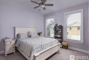 Chattanooga house for rent - A bedroom with a bed, nightstand, and a fan.