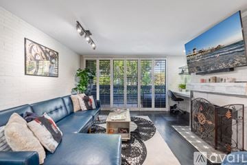 Los Angeles townhouse for rent - A living room with a blue couch and a television on the wall.