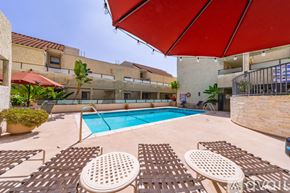 Los Angeles townhouse for rent - A pool area with sun loungers and a red umbrella.