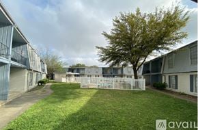 Bryan apartment for rent - A tree stands in the middle of a grassy area between two apartment buildings.