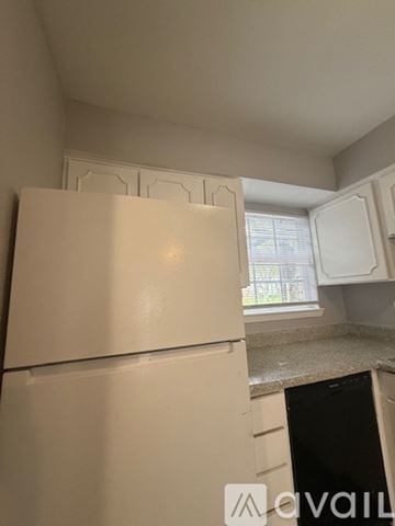 Bryan apartment for rent - A white refrigerator in a kitchen with a window in the background.
