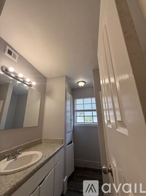 Bryan apartment for rent - A bathroom with a sink, mirror, and a window.
