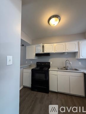 Bryan apartment for rent - A kitchen with white cabinets and a black oven.