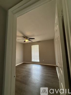 Bryan apartment for rent - A room with a ceiling fan and wooden flooring.