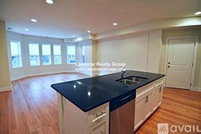 Chicago apartment for rent - A kitchen with a black countertop and wooden flooring.