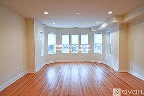 Chicago apartment for rent - A spacious room with wooden flooring and windows.
