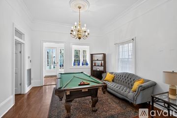 New Orleans apartment for rent - A living room with a red rug and a brown couch.