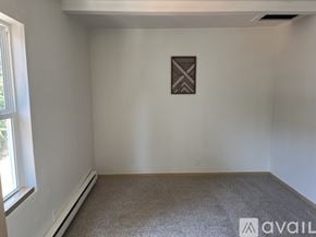 Placerville apartment for rent - A carpeted room with a picture on the wall and a window on the left.