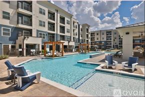 New Braunfels apartment for rent - A large swimming pool surrounded by blue lounge chairs and wooden structures.