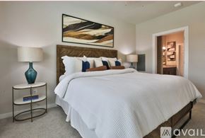 New Braunfels apartment for rent - A bedroom with a large bed, a nightstand with a lamp, and a painting on the wall.