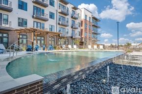 Frisco apartment for rent - A pool area with a waterfall and a building in the background.