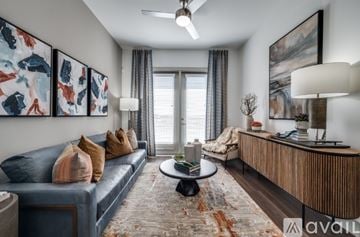 Frisco apartment for rent - A living room with a blue couch, a coffee table, and a painting on the wall.