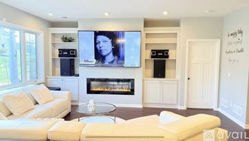 Prior Lake house for rent - A living room with a white couch and a flat screen TV mounted on the wall.