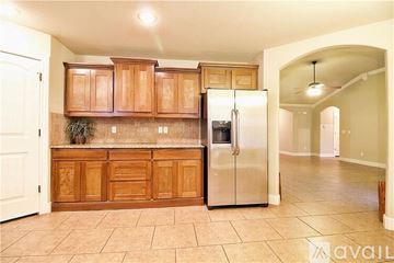 Bentonville house for rent - A kitchen with wooden cabinets and a stainless steel refrigerator.