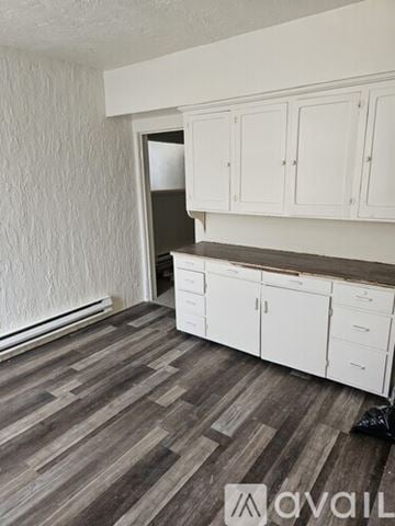 Idaho Falls apartment for rent - A kitchen with white cabinets and a wooden floor.