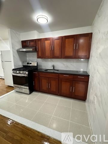 Queens apartment for rent - A kitchen with wooden cabinets and a white refrigerator.