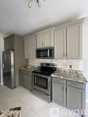 Simpsonville house for rent - A kitchen with a stove top oven and microwave above it.
