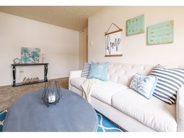Parma apartment for rent - A living room with a white couch and a blue ottoman.