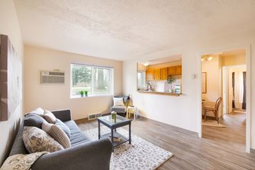 Parma apartment for rent - A living room with a grey couch and a glass coffee table.