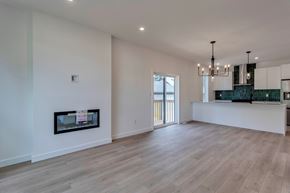Edmonton apartment for rent - A spacious living room with a fireplace and a chandelier.