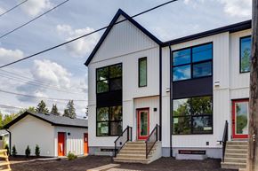 Edmonton apartment for rent - A modern house with a red door and a black roof.