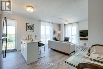 Oshawa (O'neill) condo for rent - A living room with a white couch and a glass table.