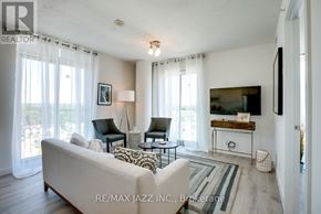 Oshawa (O'neill) condo for rent - A living room with a couch, chair, and television.