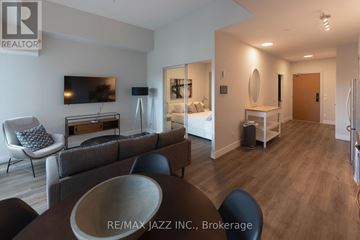 Oshawa (O'neill) condo for rent - A modern living room with a grey couch and a wooden table.