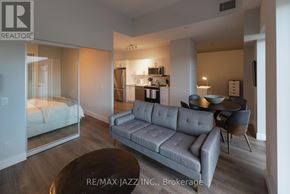 Oshawa (O'neill) condo for rent - A modern living room with a grey couch and a round coffee table.