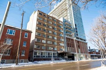 Ottawa apartment for rent - A tall building with a glass facade stands next to a shorter brick building.