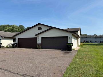 Menomonie apartment for rent - A two-car garage is attached to a house.