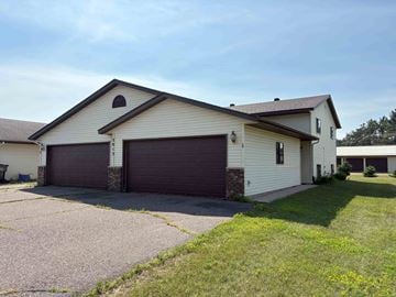 Menomonie apartment for rent - A two-car garage is attached to a house.