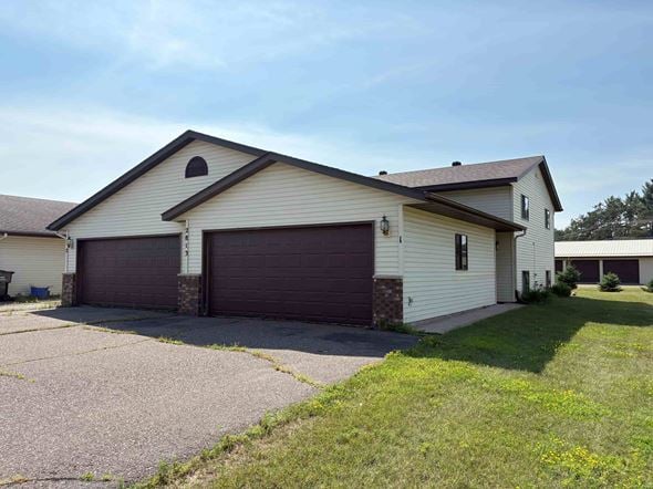 Menomonie apartment for rent - A two-car garage is attached to a house.