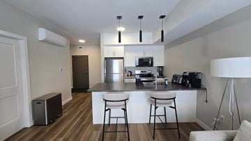 Dryden apartment for rent - A kitchen with a white counter and bar stools.