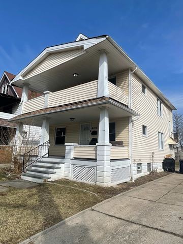 Cleveland apartment for rent - A two-story house with a front porch and a staircase leading to the entrance.