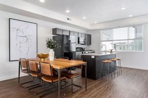 West Jordan apartment for rent - A modern kitchen with a wooden table and chairs.