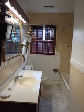 Louisville apartment for rent - A bathroom with a sink, mirror, and toilet.