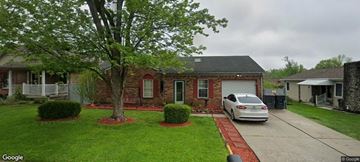New Albany house for rent - A white car is parked in front of a brick house.