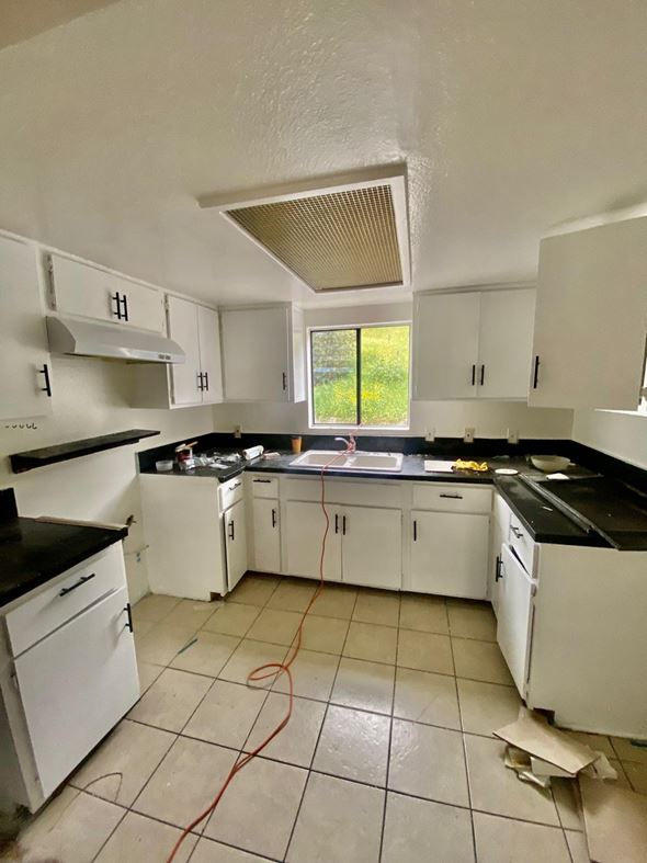 Los Angeles apartment for rent - A kitchen with white cabinets and black countertops is under construction.