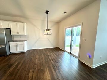 Greer house for rent - A kitchen with white cabinets and a wooden floor.