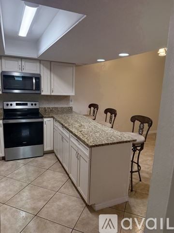Titusville house for rent - A kitchen with a granite countertop and a microwave above the stove.