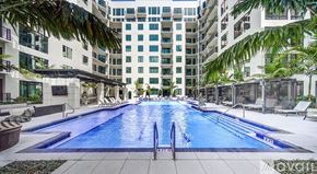 Sarasota townhouse for rent - A large indoor swimming pool with lounge chairs and palm trees.