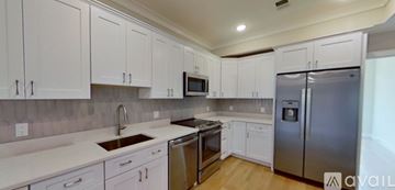 Boston apartment for rent - A kitchen with white cabinets and a stainless steel refrigerator.