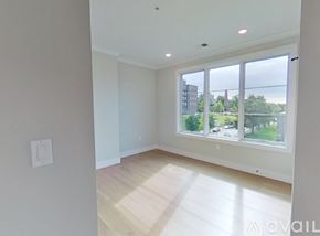 Boston apartment for rent - A spacious room with a large window overlooking a green landscape.