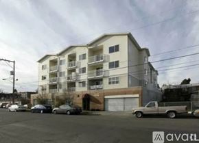 Seattle apartment for rent - A large apartment building with a parking lot in front of it.